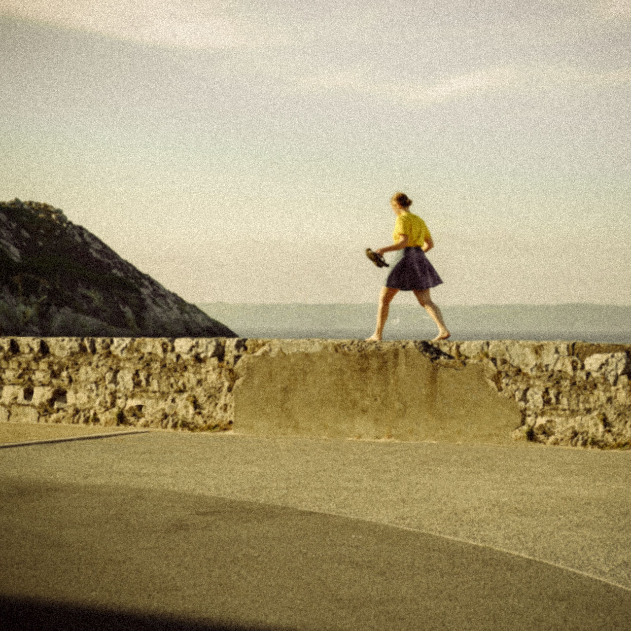 Jeune fille en jaune qui marche sur un mur, lang="fr" Jeune fille en jaune qui marche sur un mur